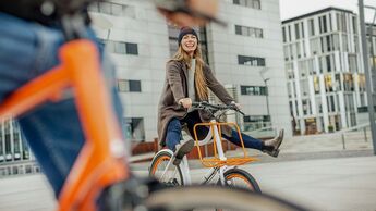 Carefree woman with man riding bicycle in the city