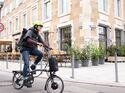 City E-Bike I Test E-Faltrad Brompton Electric P-Line Urban I Frau auf Brompton Faltrad in der Stadt