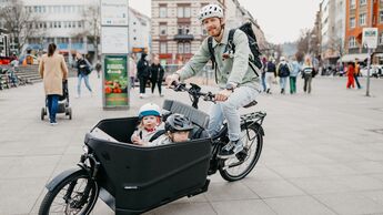 E-Lastenrad I Test Riese und Müller Packster 70 Vario I Fahrbild Mann mit zwei Kindern - Familien-Lastenrad