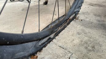 Flat old dusty bike tire on ground
