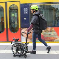 Frau mit Brompton E-Faltrad steigt in U-Bahn ein
