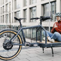 Frau sitzt auf Ladefläche beim E-Lastenrad Bullitt ePinion