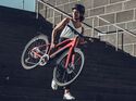 Frau trägt leichtes E-Bike Treppenstufen herab