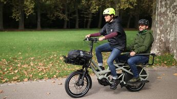Frau und Mann fahren gemeinsam auf E-Lastenrad vom Hersteller Tern, Longtail Lastenrad