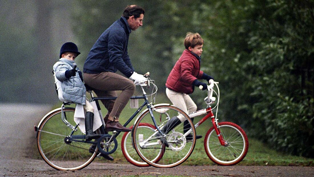König CHarles III fährt Fahrrad mit seinen Söhnen Harry und William in Sandringham Estate, Norfolk.