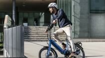 Mann mit E-Bike Helm auf City E-Bike