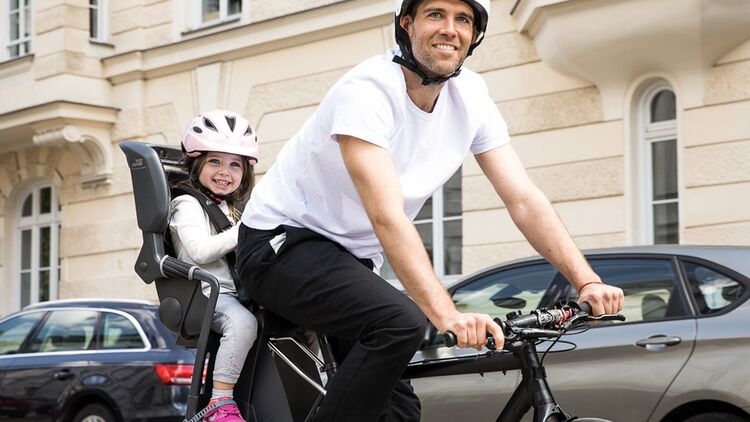 Mann mit Fahrrad und Kind im Kindersitz