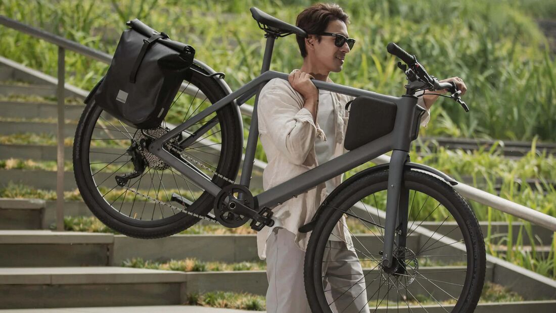 Mann trägt leichtes Urban E-Bike LEMO One