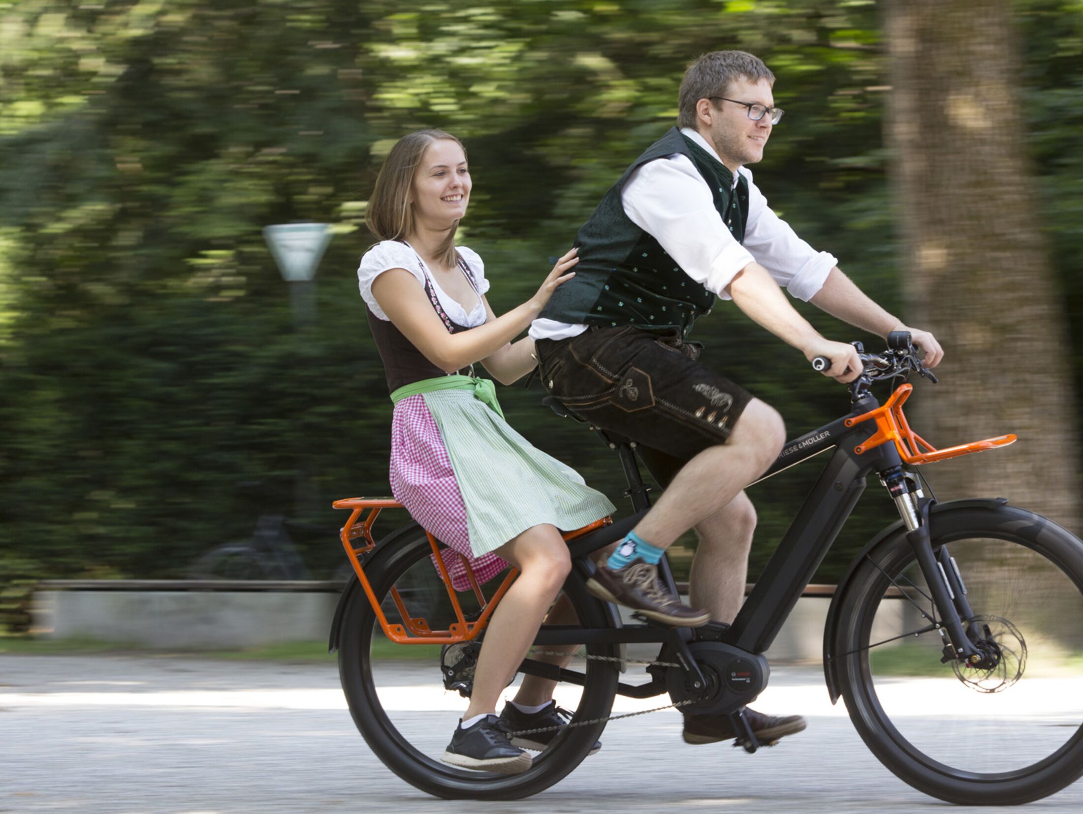Menschen auf einem elektrischen Fahrrad mit farbenfroher