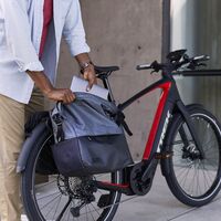 Mann zieht ein Notebook aus der Fahrradtasche