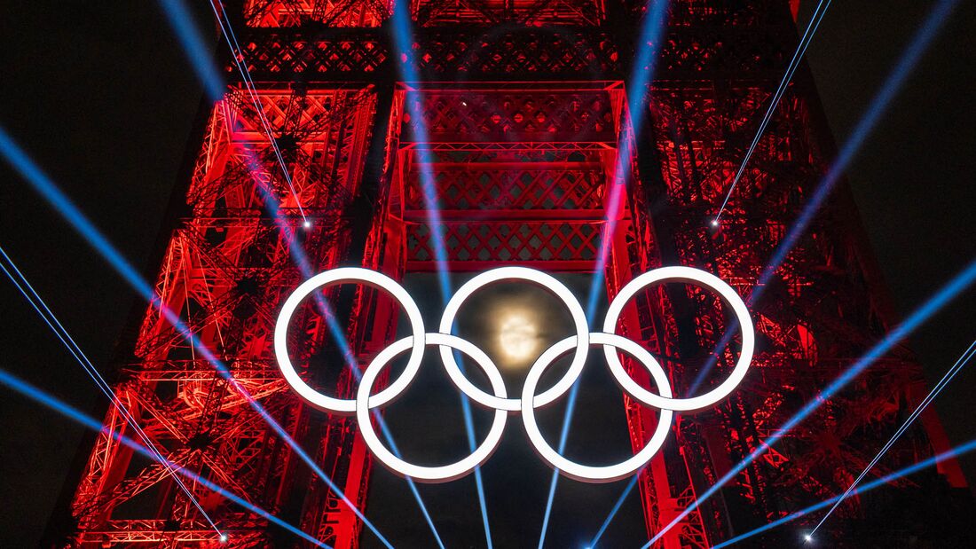 The moon behind the Olympic rings on display at the Eiffel Tower