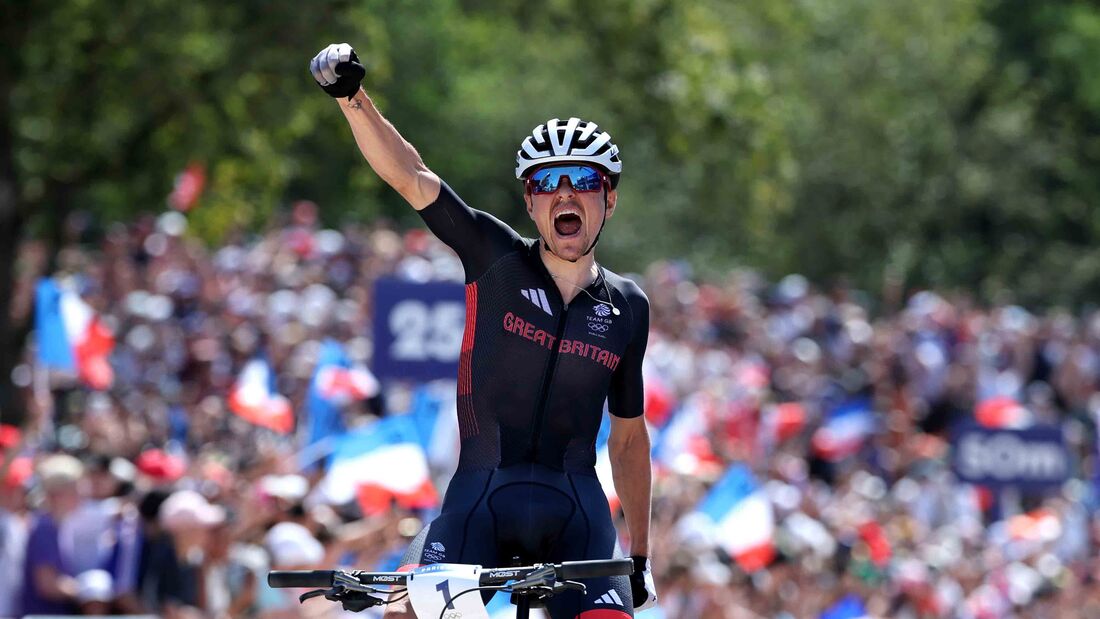 Thomas Pidcock of Team Great Britain celebrates at finish line as gold medal winner during the Men's Cross-Country on day three of the Olympic Games Paris 2024 at Elancourt Hill on July 29, 2024 in Elancourt, France. (Photo by Alex Broadway/Getty Images)