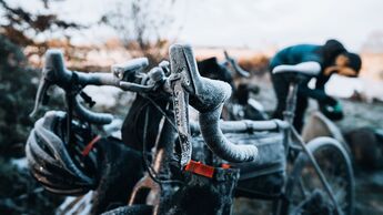 Vertical shot of a bicycle and a helmet covered with snow during winter frost
