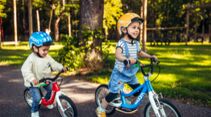 Zwei Kinder fahren auf ihrem Woom Laufrad