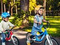 Zwei Kinder fahren auf ihrem Woom Laufrad