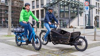 Zwei Männer auf Elektro-Lastenrad in der Stadt